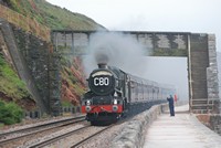 [A steam train passing the red cliffs at Dawlish]